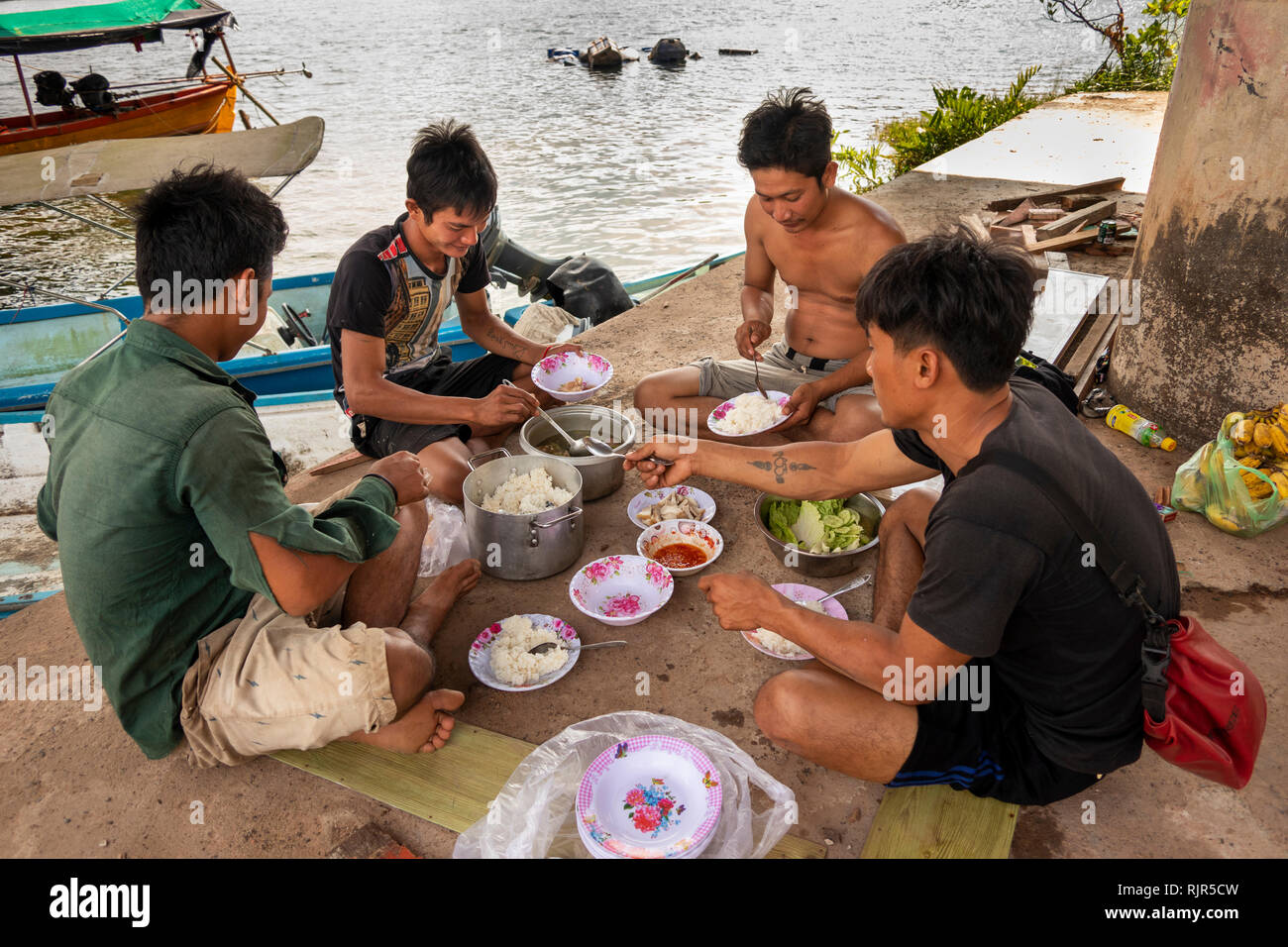 Kambodscha, Koh Kong Provinz, Tatai, Gruppe der Männer essen mittags Essen, im Schatten der Brücke Stockfoto