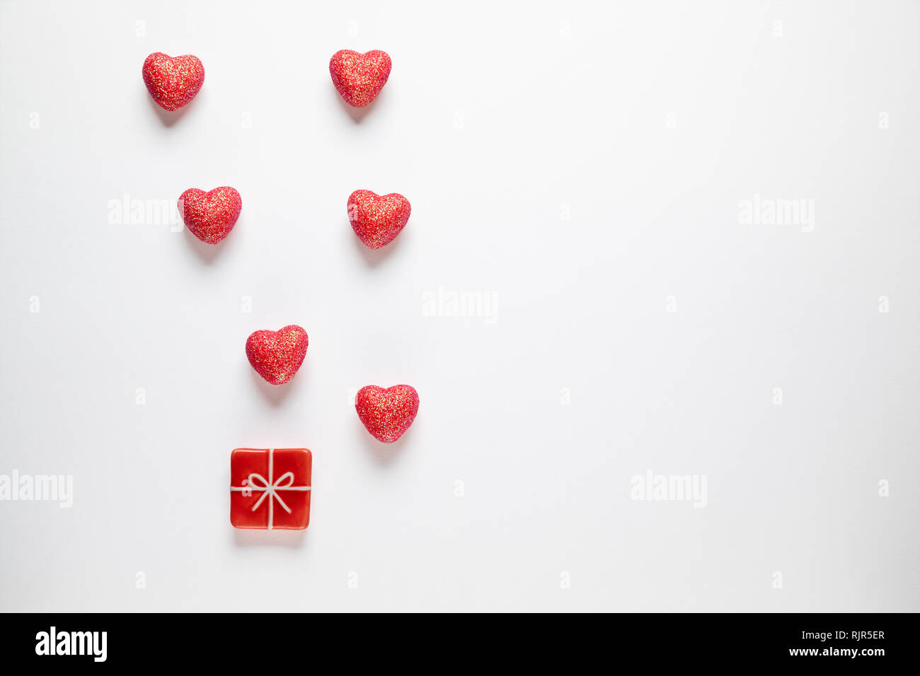 Sparkle Herzen und Spielzeug vorhanden auf weißem Hintergrund. Valentinstag Hintergrund. Stockfoto