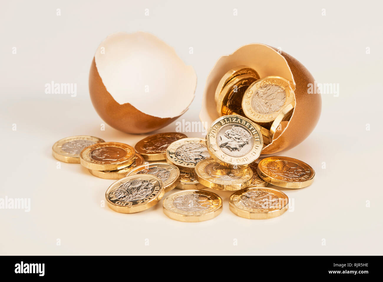 Golden Nest Ei mit Shinny Pfund Münzen Stockfoto
