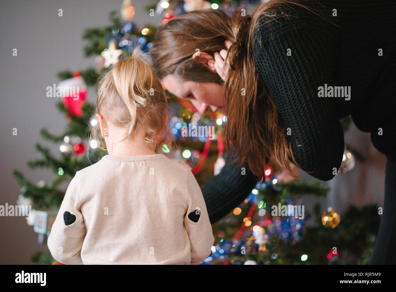 Mutter und Tochter schmücken Weihnachtsbaum Stockfoto