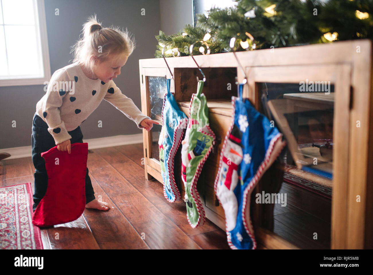 Kleinkind Mädchen hängen bis Weihnachten Strümpfe Stockfoto