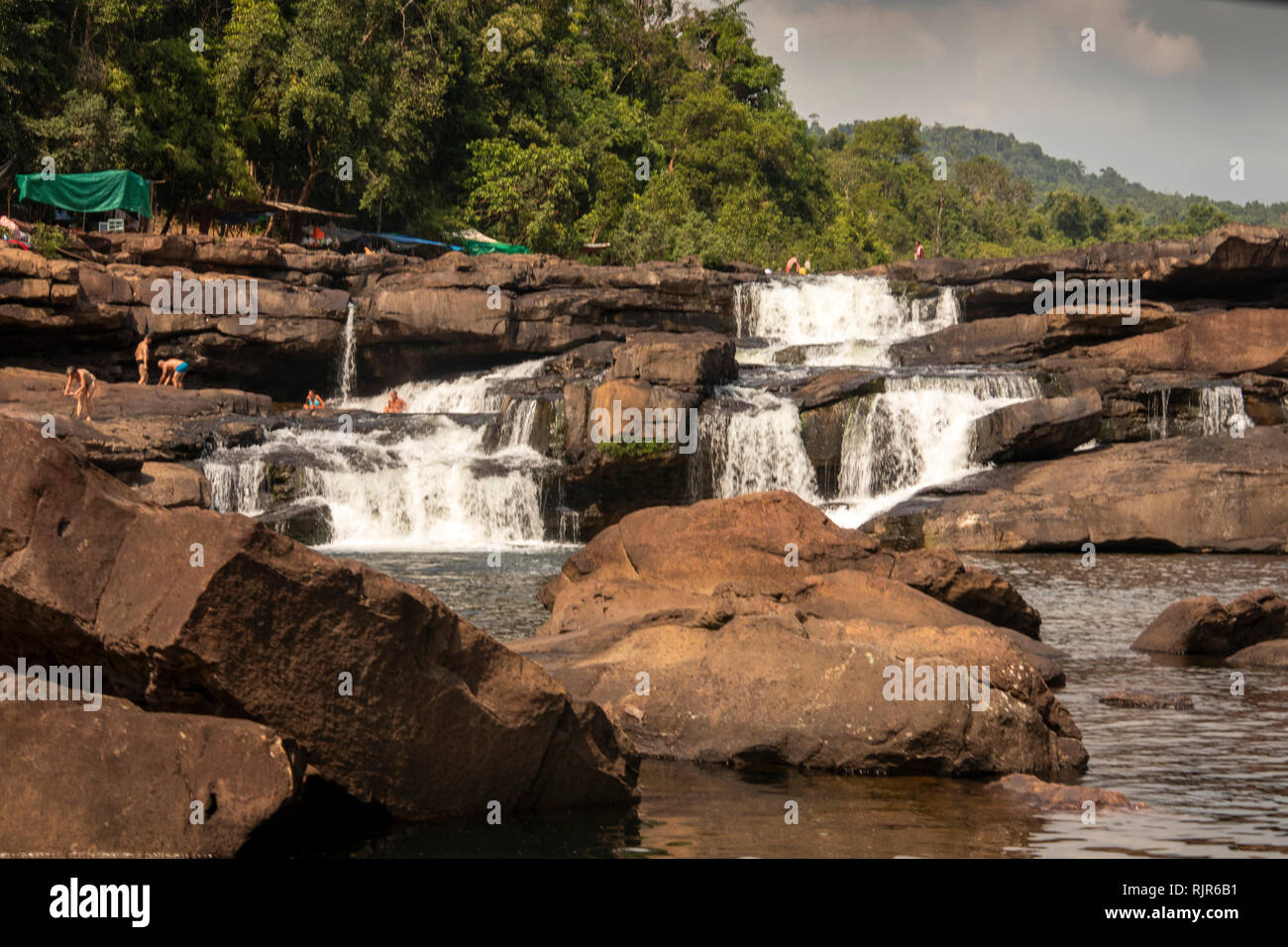 Kambodscha, Koh Kong Provinz, Tatai, Wasserfall, Touristen auf Felsen unter Wasser über fließende in der trockenen Jahreszeit fällt. Stockfoto
