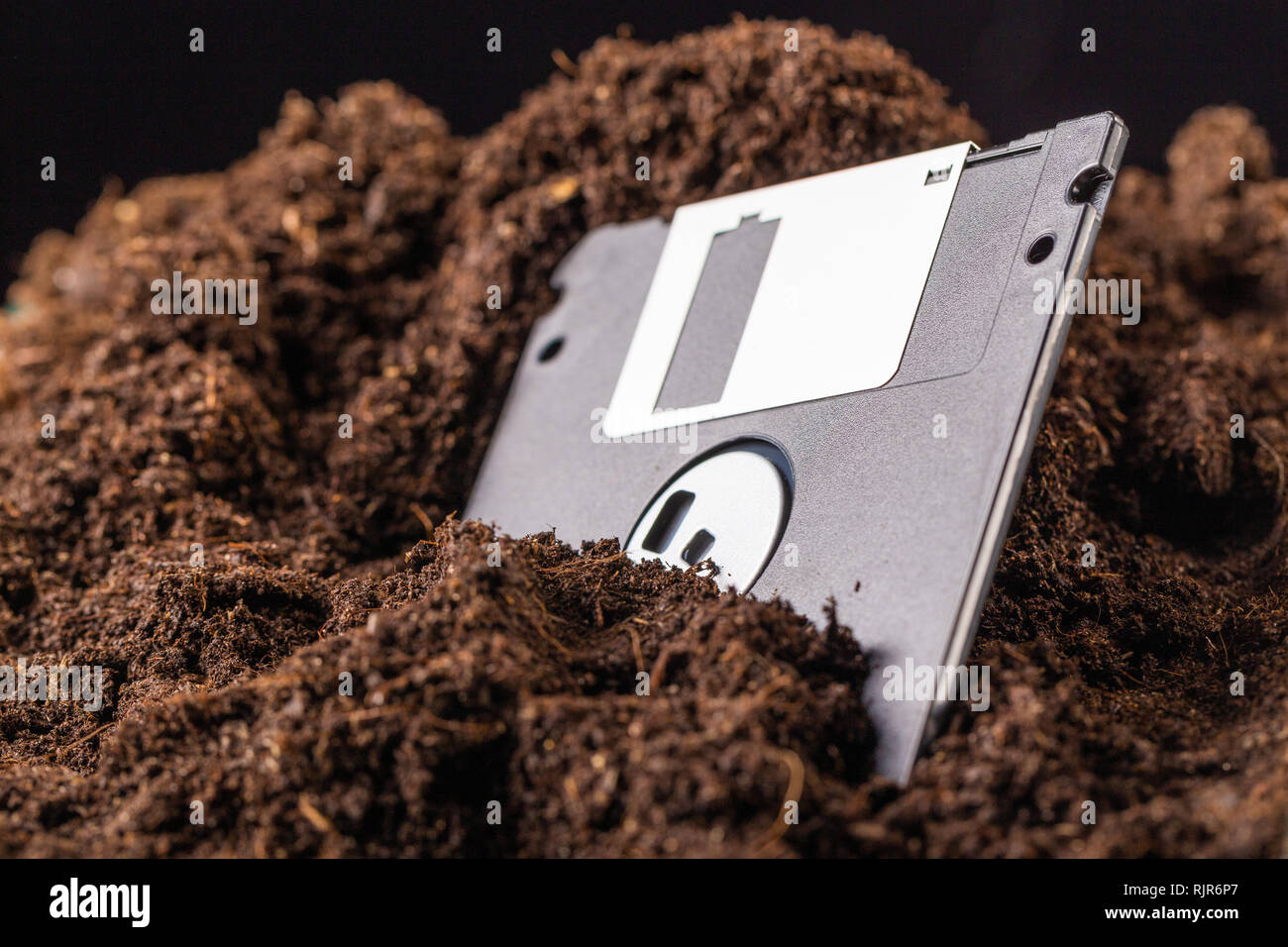 Die Diskette ist halb in die Erde eingegraben. Stockfoto