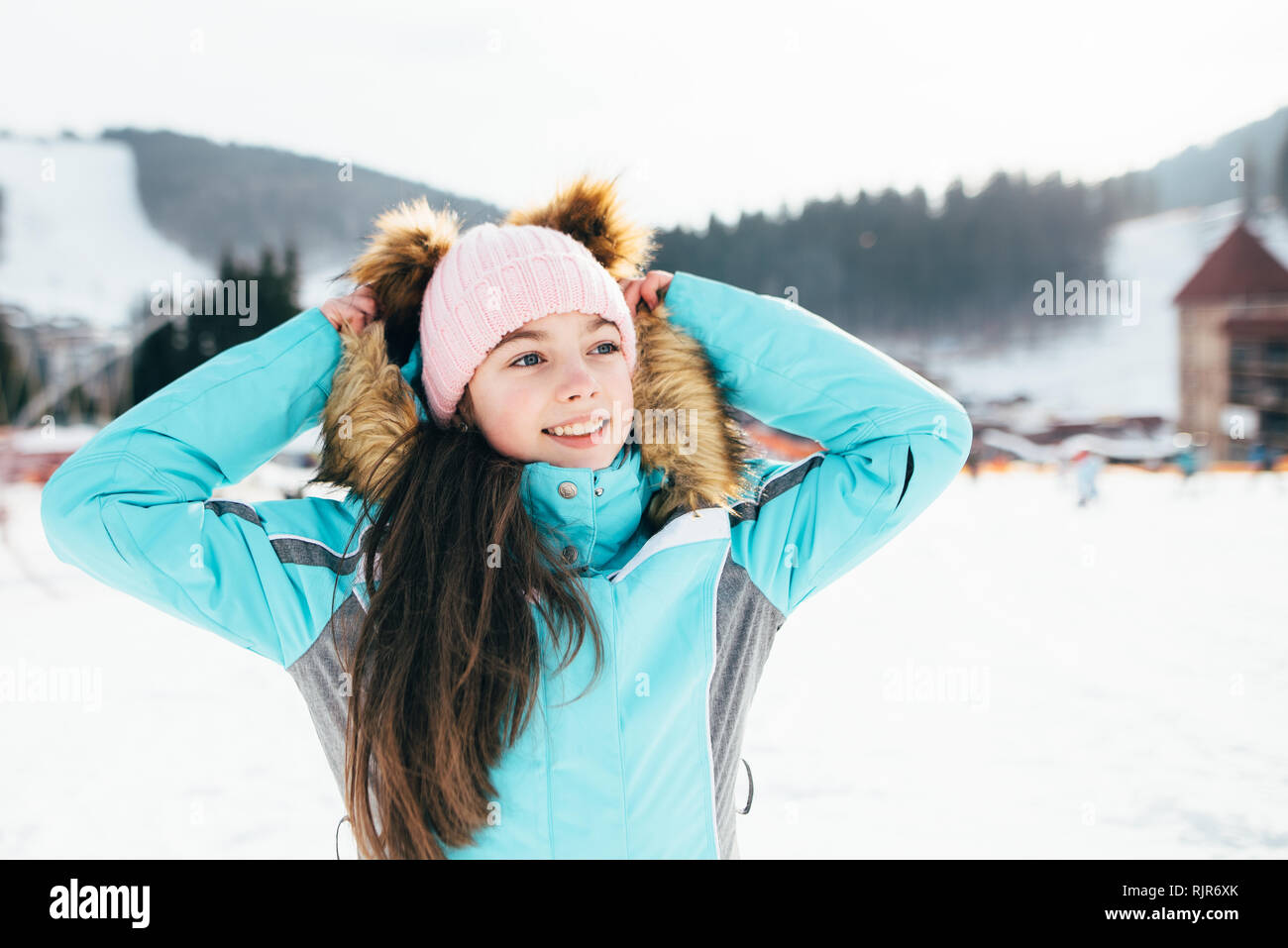 Schöne Mädchen in einer Skijacke Spaziergänge an einem sonnigen Frühlingstag in den Bergen Stockfoto