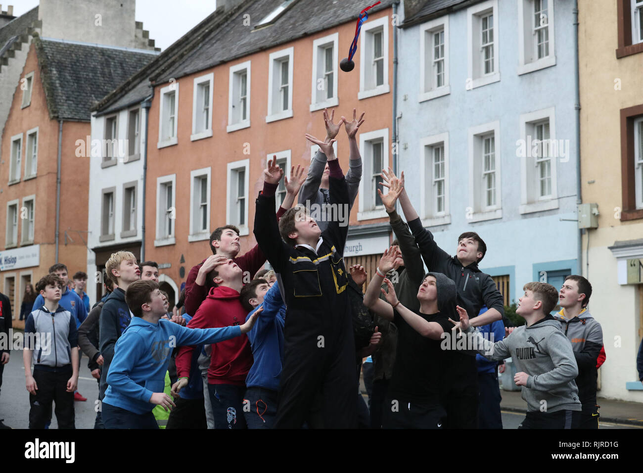 Jungen springen das Leder Ball während der jährlichen "Fastern&Otilde zu verfangen; s E'en Hand Ba'Ereignis auf Jedburgh High Street in den schottischen Borders. Stockfoto