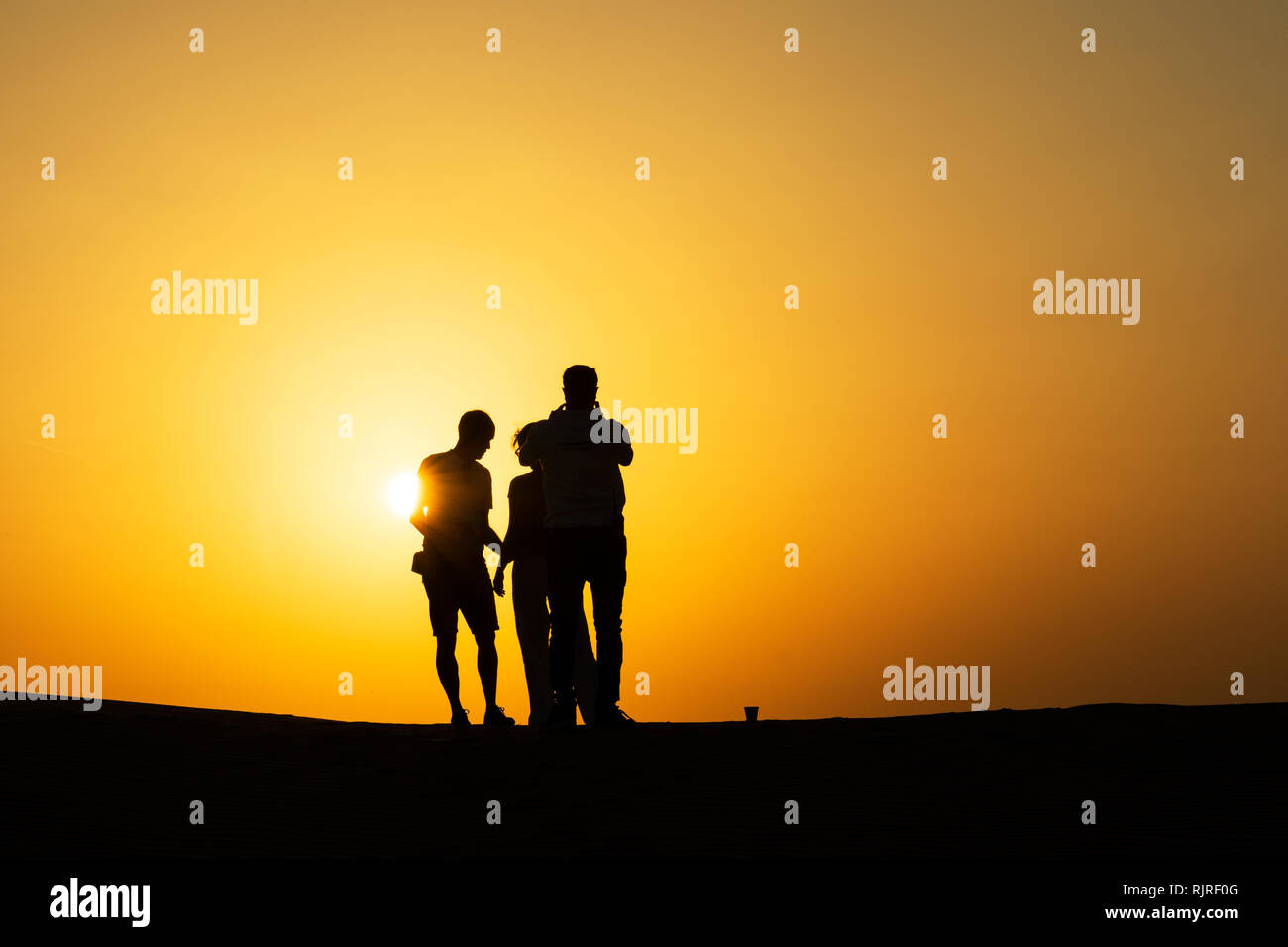 Gruppe von Freunden Spaß in der Abu Dhabi Wüste auf einer Düne mit Sonnenuntergang. Stockfoto