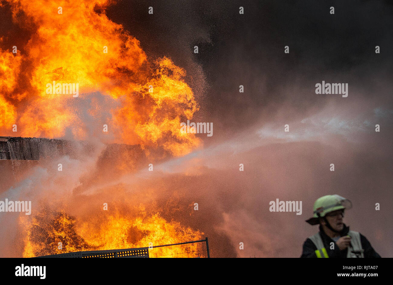 Moers, Deutschland. 08 Feb, 2019. Feuerwehrmänner bekämpfen einen Brand in einem kommerziellen Halle. Die Moers Bahnhof wurde aufgrund der starken Rauchentwicklung geschlossen. Anwohner wurden gebeten, von der Feuerwehr, Türen und Fenster geschlossen zu halten. Credit: Christoph Reichwein/dpa/Alamy leben Nachrichten Stockfoto