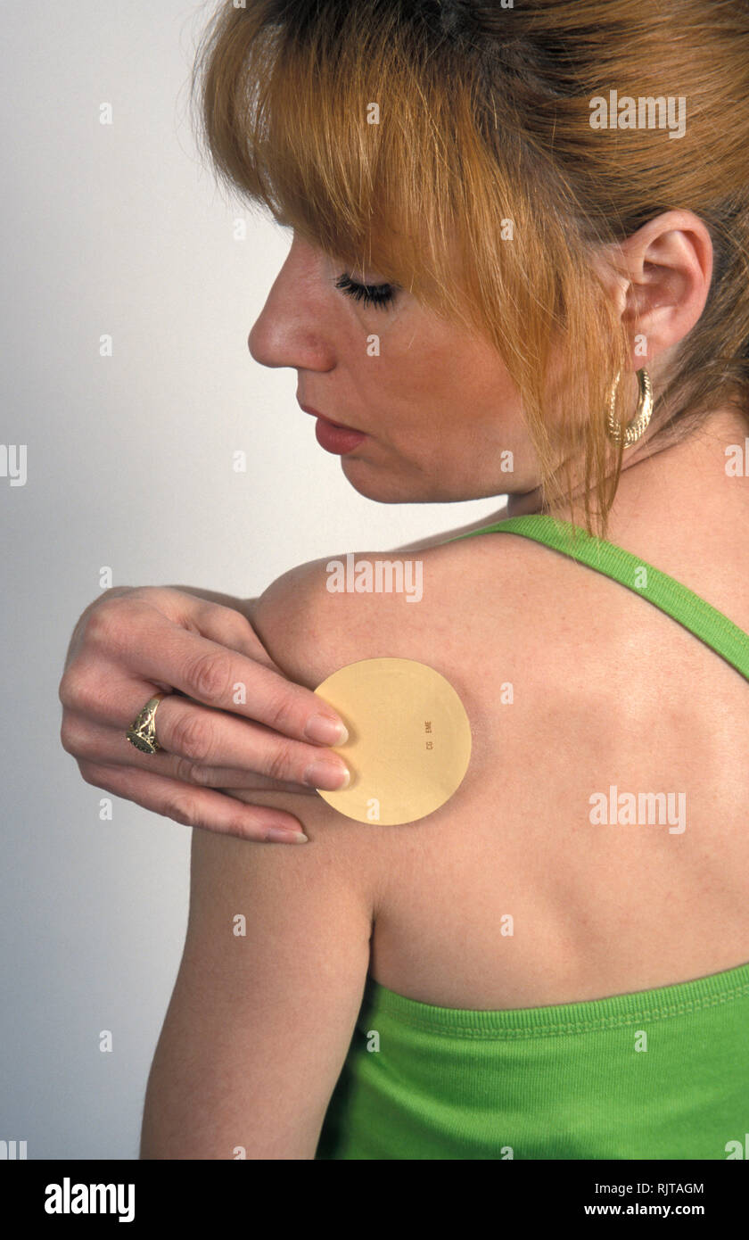 Frau klemmt Nikotinflecken auf ihrem Arm Stockfoto