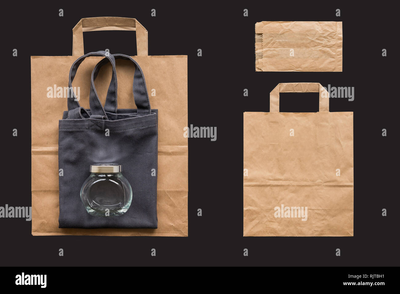 Einkaufstasche aus Baumwolle, Papier und Glas isoliert auf dem schwarzen Hintergrund Stockfoto