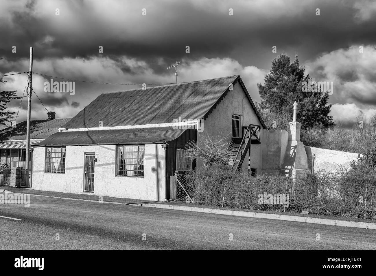 SUTHERLAND, SÜDAFRIKA, August 7, 2018: eine Straße, Szene, mit einem alten Haus mit Loft, in Sutherland in der Northern Cape Provinz. Schwarzweiß Stockfoto