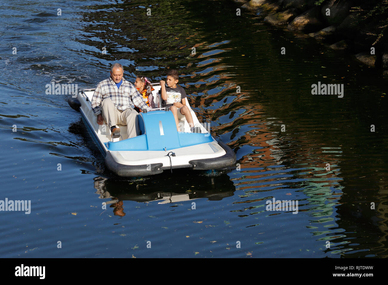 Malmö, Schweden - 23 August 2017: Ein Erwachsener und zwei Kinder in einem blauen und weißen Tretboot fahren. Stockfoto