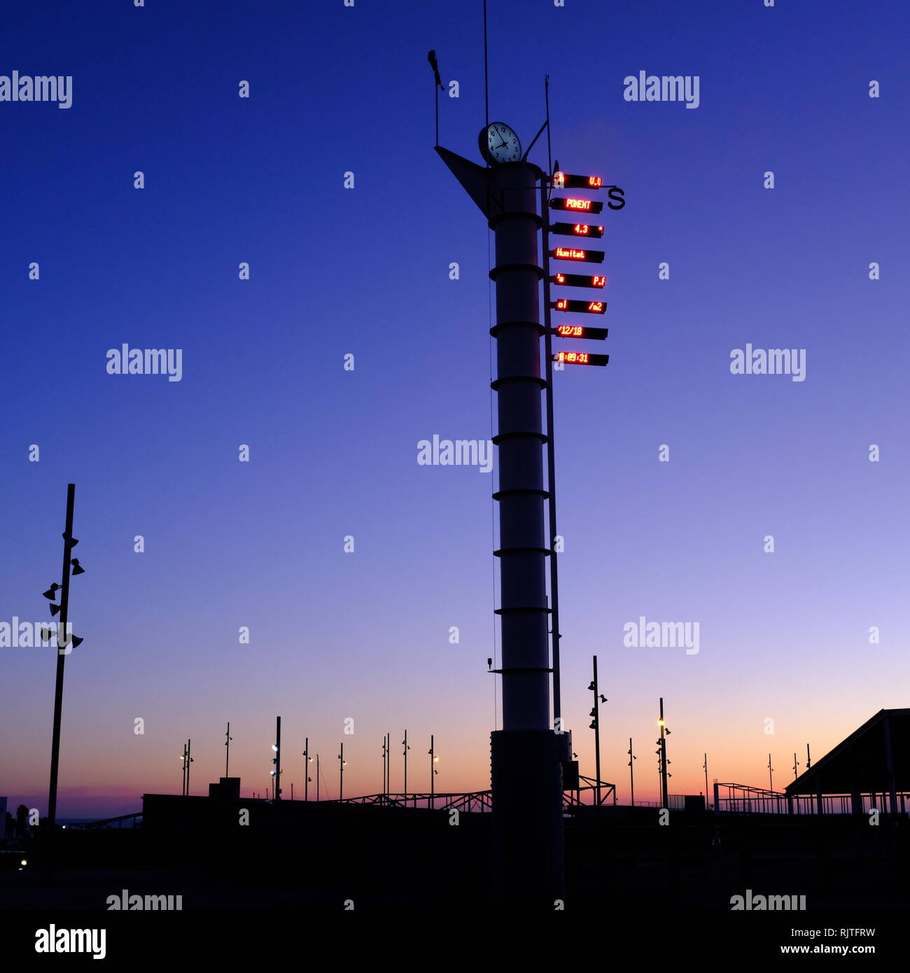 Wetter Vene und Uhrturm mit digitaler Temperaturanzeige gegen den strahlend blauen Himmel Silhouette dawn Stockfoto