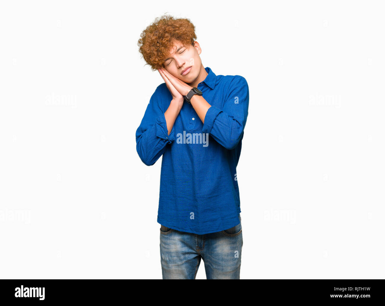Jungen schönen eleganten Mann mit afro Haar müde schlafen, träumen und mit den Händen zusammen posieren während lächelnd mit geschlossenen Augen. Stockfoto