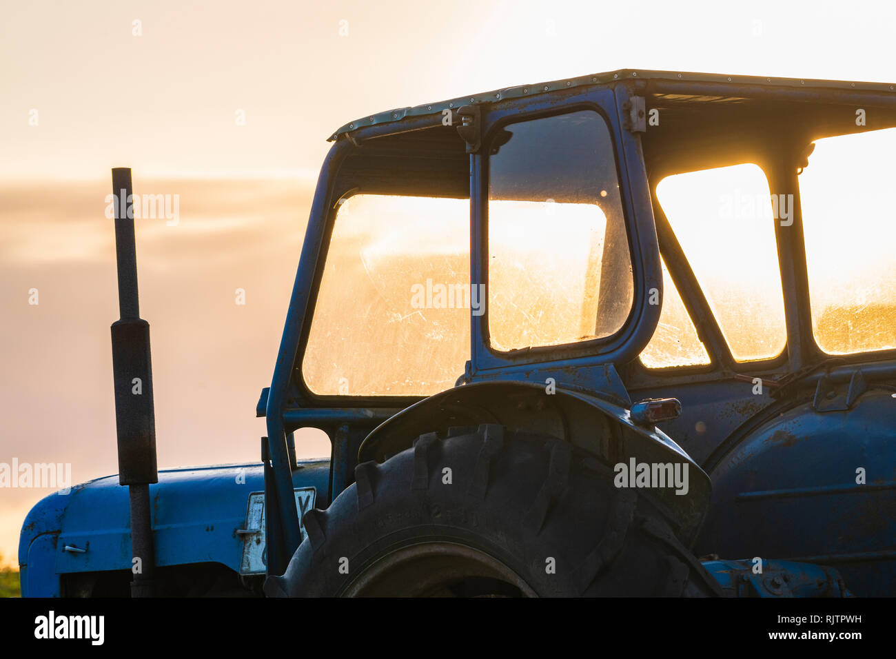 Durch die Fenster des stehenden Traktors bei Sonnenaufgang, Nahaufnahme, beschnitten, Halland, Schweden, Europa Stockfoto