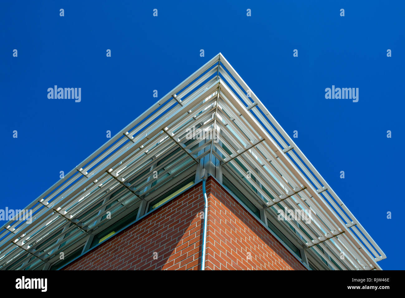 Ecke eines Gebäudes Dach mit shadowing Gitter über der Windows. Stockfoto
