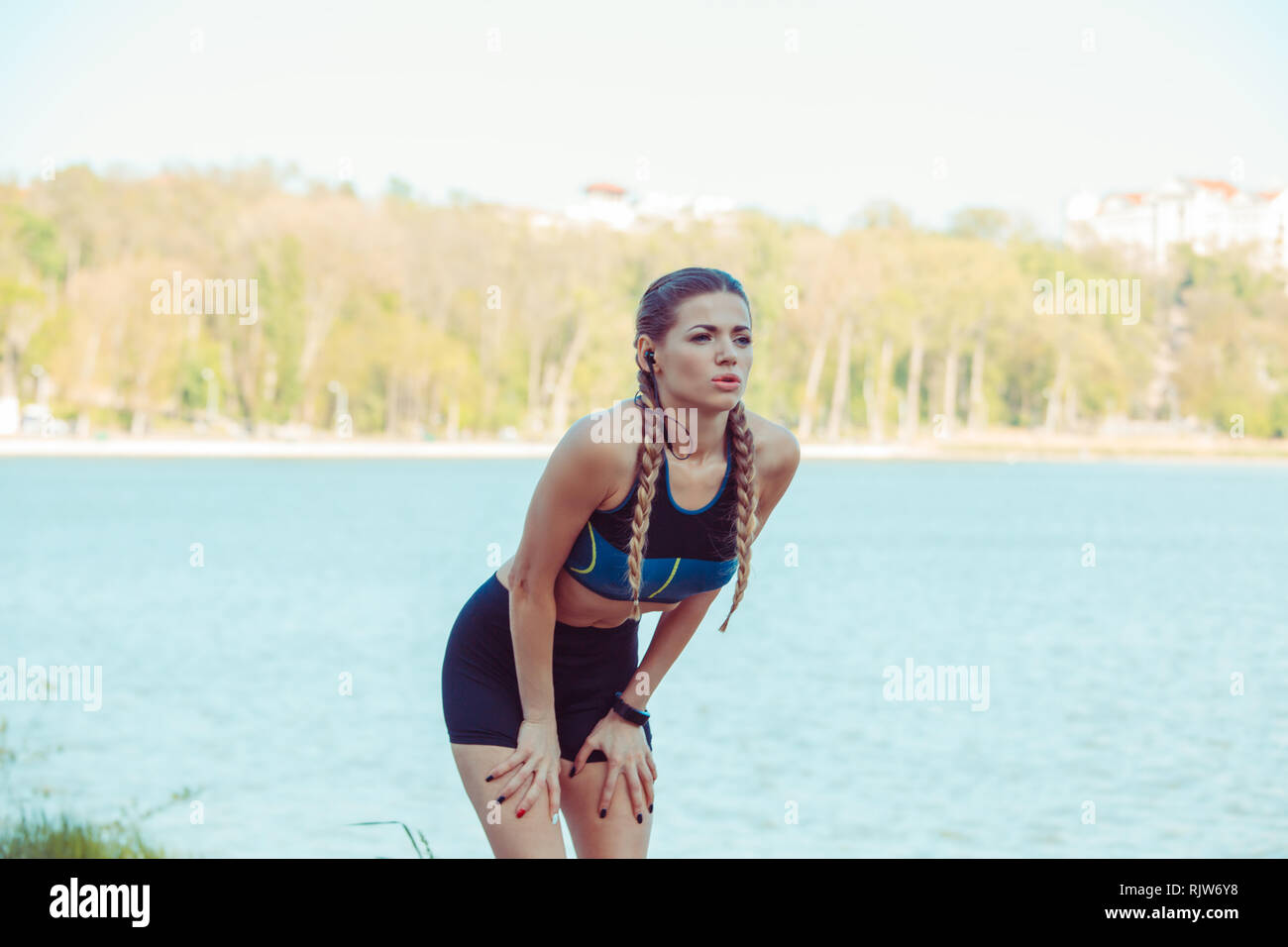 Schöne sportliche weibliche Jogger müde nach dem Ausführen ihrer atemberaubenden Stockfoto