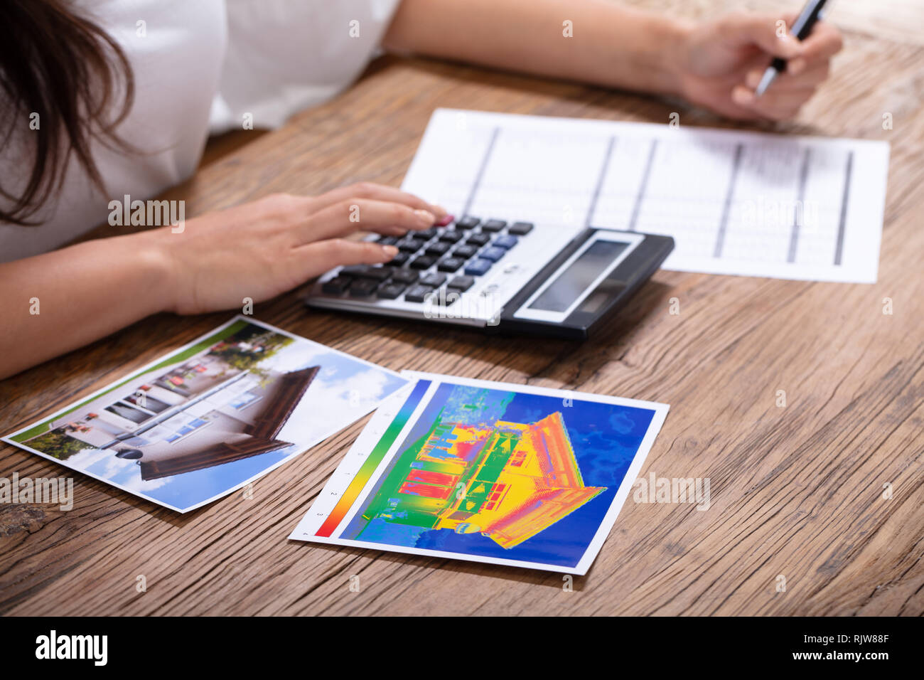 Nahaufnahme einer Person die Berechnung der Wärmeverluste und die Energieeffizienz eines Hauses Stockfoto