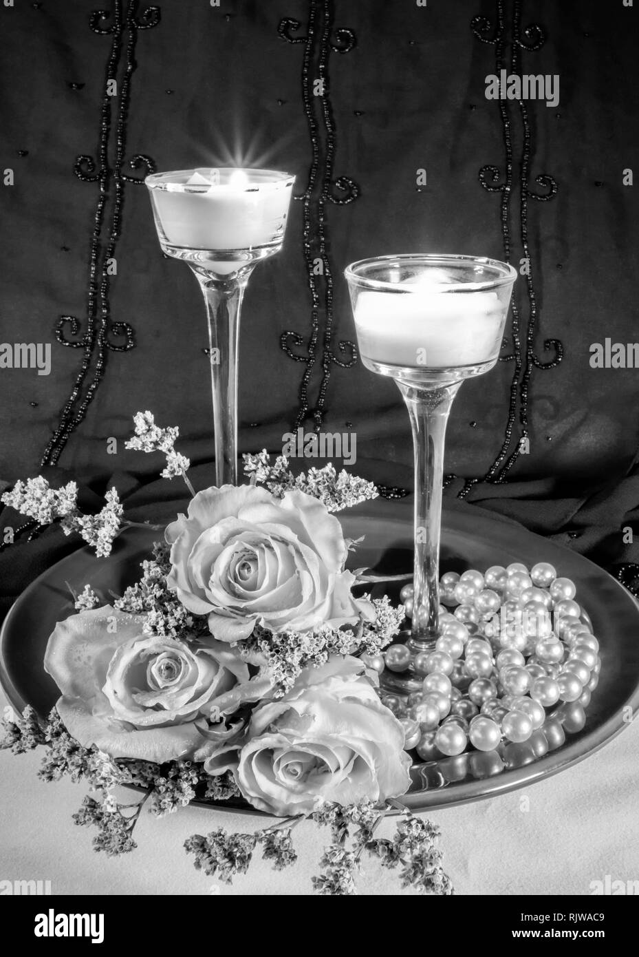 Schwarz-Weiß - Rosen mit Kerzen & Perlen Stockfoto