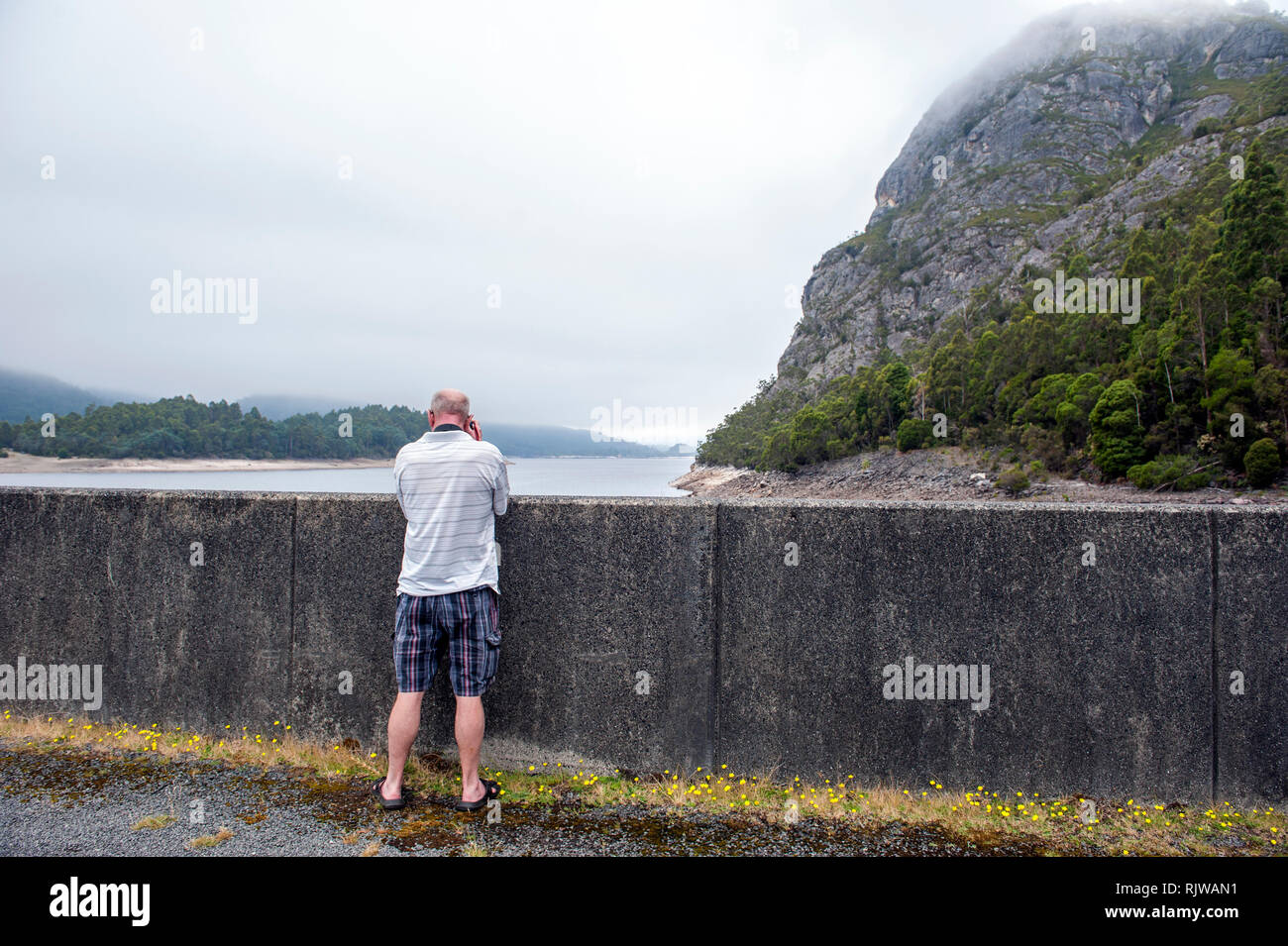 Ein Tourist, der ein Foto von Lake Mackintosh, einen Vorratsbehälter, die Bestandteil des Pieman Wasserkraftwerken, die Regelung in der Nähe von Tullah in Tasmanien. Stockfoto