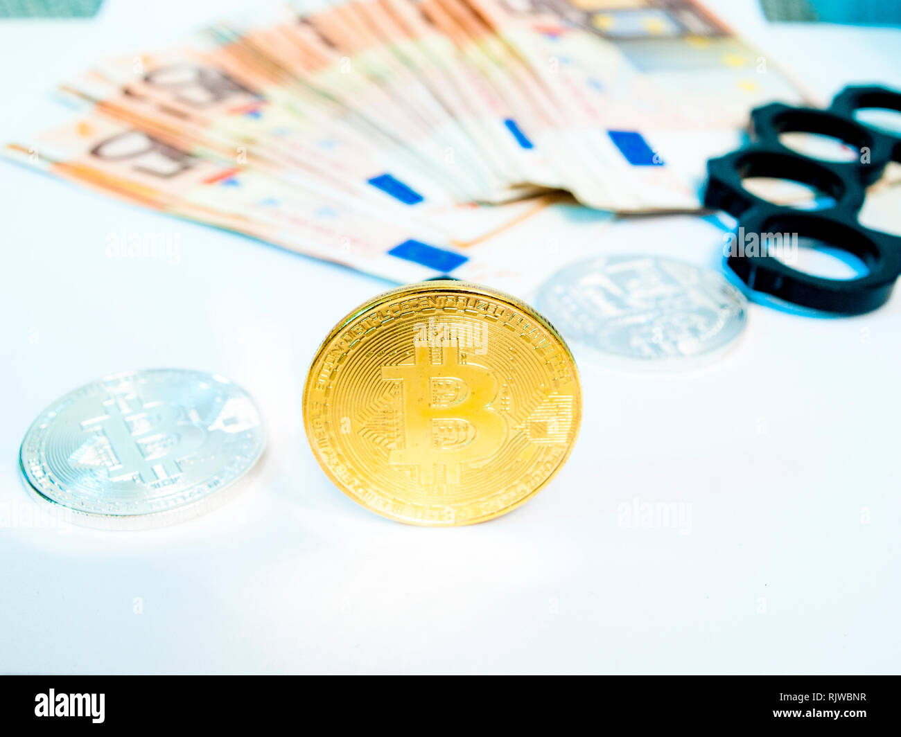 Nahaufnahme von bitcoin, Euro, Bügeleisen Knöchel Knöchel - duster der Kriminalität und der Stapel Papier euro Banknote. Europäisches Geld Währung nominale fünfzig Euro. Stockfoto