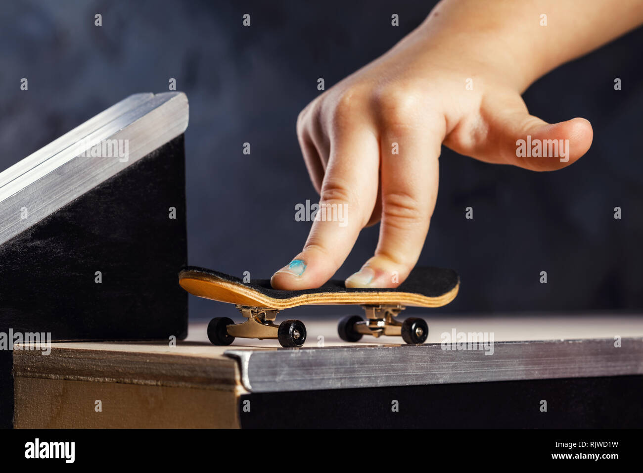 Eine spannende Aktivität für ein Kind, reiten ein Mini Skateboard oder Griffbrett auf einem speziell ausgestatteten Track. Stockfoto