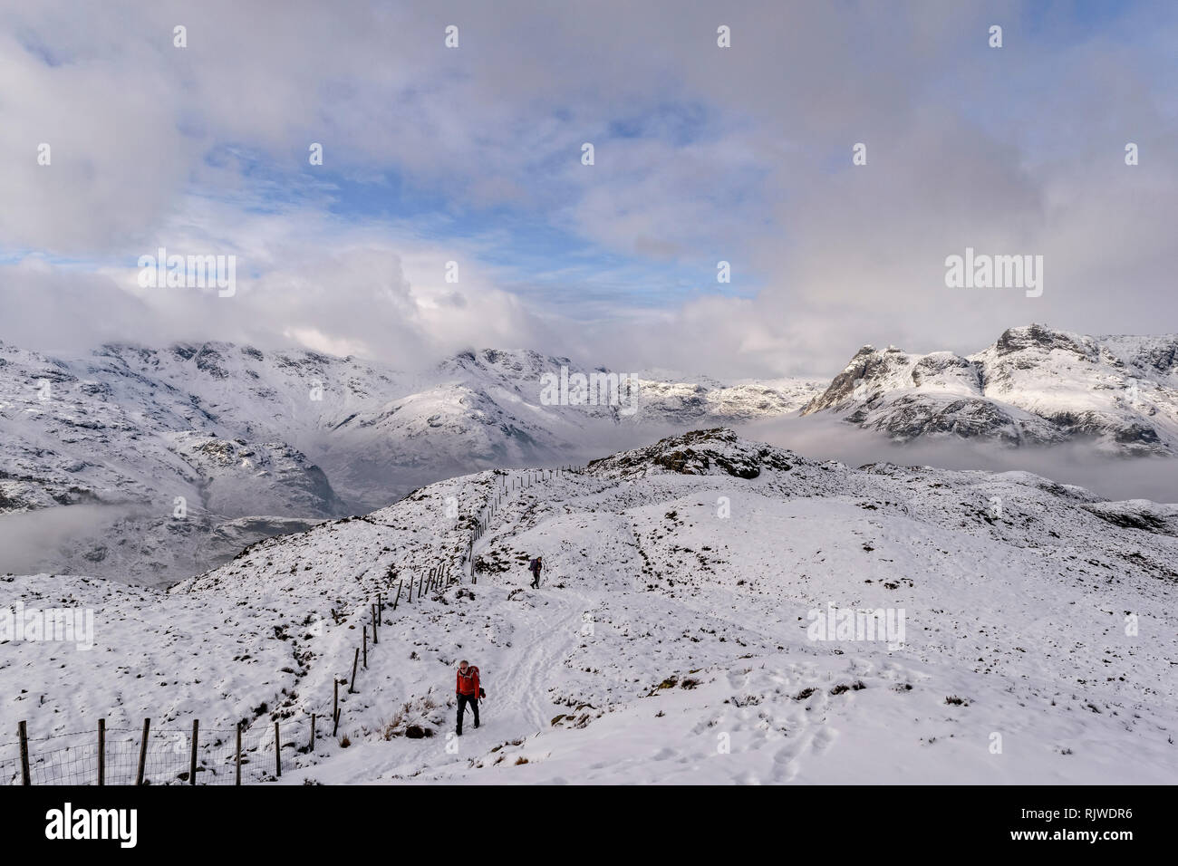 Wanderer auf einem schneebedeckten Lingmoor mit herrlichem Blick auf die hohen Berge über der Cloud Inversion Stockfoto
