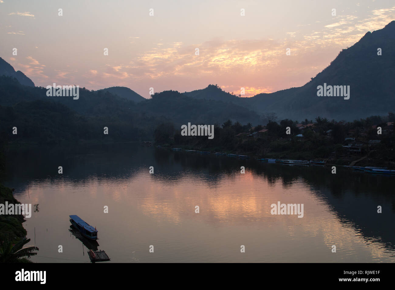 Sonnenuntergang mit Boot am Nam Ou Fluss am Dorf Nong Khiaw vom Gästehaus entfernt, einem beliebten Backpacker Reiseziel in der Nähe von Luang Prabang in Laos. Stockfoto Sonnenuntergang mit Boot am Nam Ou Fluss am Dorf Nong Khiaw vom Gästehaus entfernt, einem beliebten Backpacker Reiseziel in der Nähe von Luang Prabang in Laos. Stockfoto