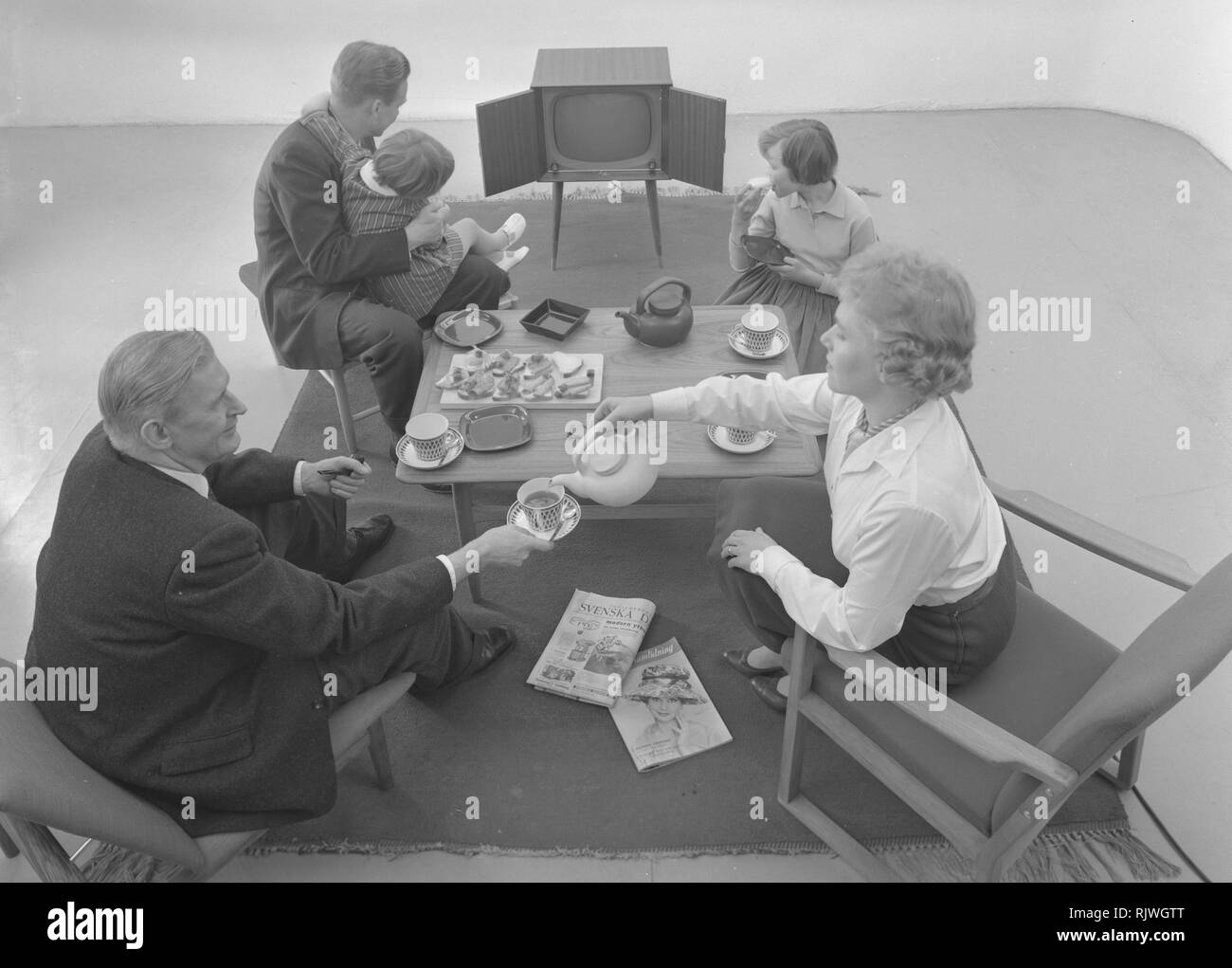 Fernsehen in den 1950er Jahren. Familie vor einem Fernseher und durch das neue Medium Fernsehen fasziniert im März 1959. Schweden Stockfoto