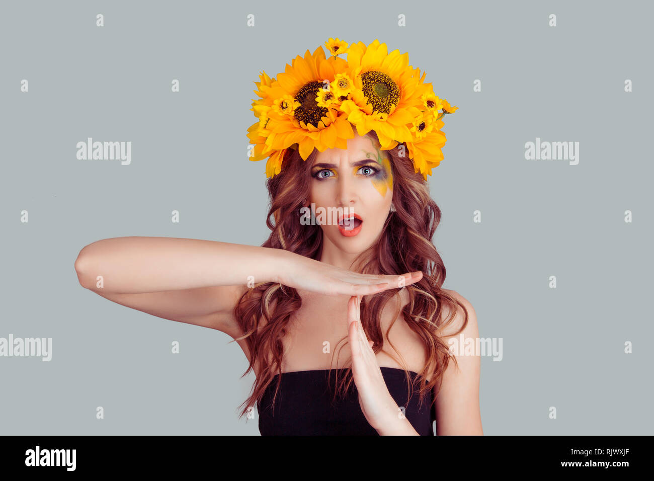 Frau in Sonnenblumen blumen Krone Zeit angezeigt, Geste Stockfoto