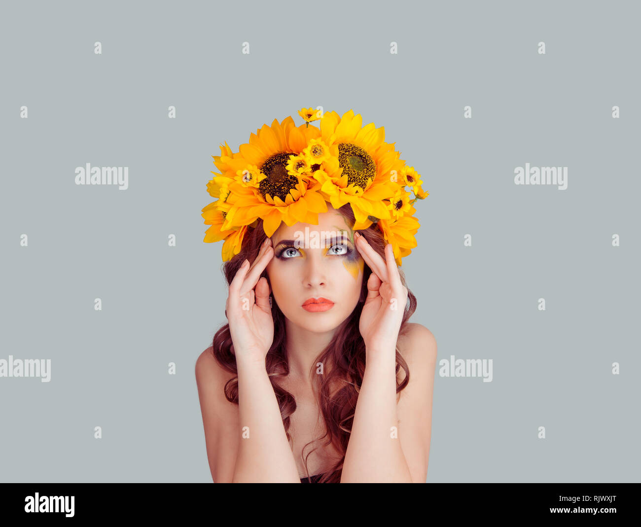 Frau mit Blumen stirnband Hände auf Tempel Kopf tief Denken Stockfoto