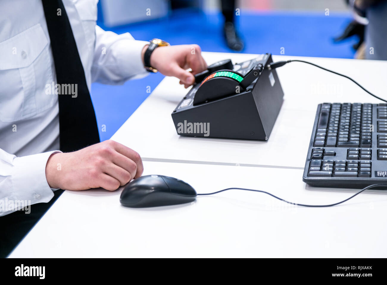 Mann mit weißem T-Shirt vor einem Computer Controller, Tastatur Stockfoto