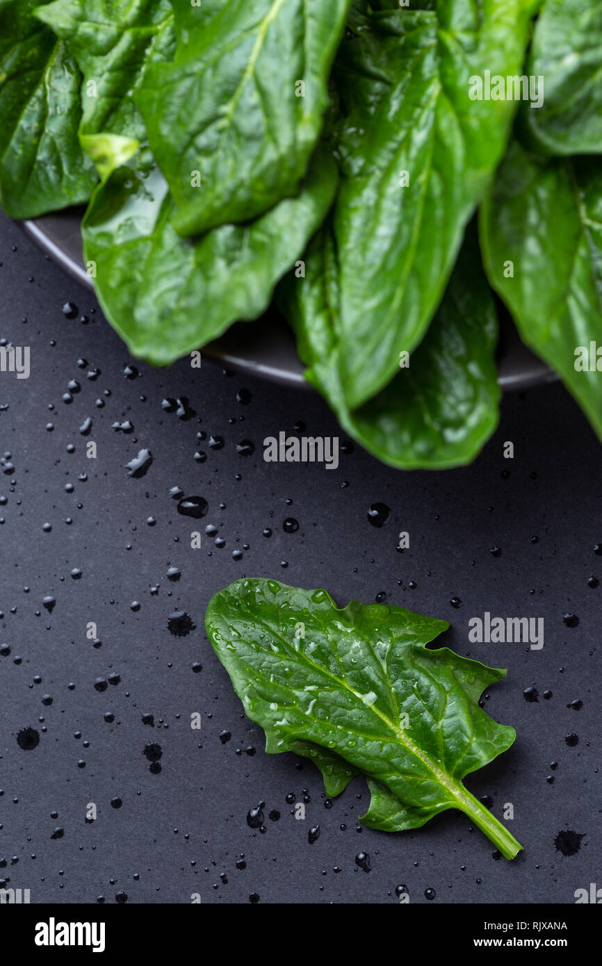 Frische Spinatblätter auf dunklem Marmor tisch Hintergrund. Gesunde Ernährung, Diät oder Kochen Konzept Stockfoto
