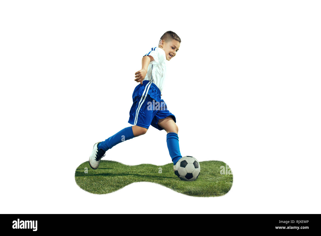 Junge kickt den Ball. Foto auf weißem Hintergrund. Fußball-Spieler in Bewegung im Studio. Fit springen Junge in Action, Jump, Bewegung im Spiel. Stockfoto