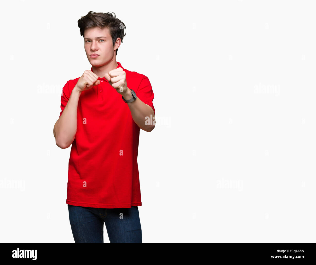 Jungen gutaussehenden Mann tragen rote T-Shirt über isolierte Hintergrund Stanzen Faust zu kämpfen, aggressiv und wütend Angriff, Bedrohung und Gewalt Stockfoto