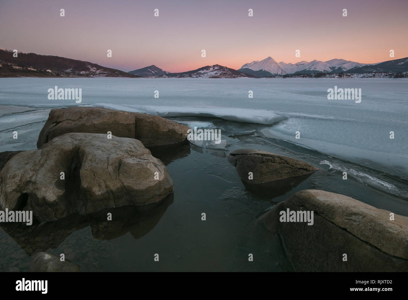 Risse auf der Oberfläche des Eises. Gefrorenen See im Winter Berge. Campotosto See im Gran Sasso e Monti della Laga Nationalpark der Abruzzen Stockfoto