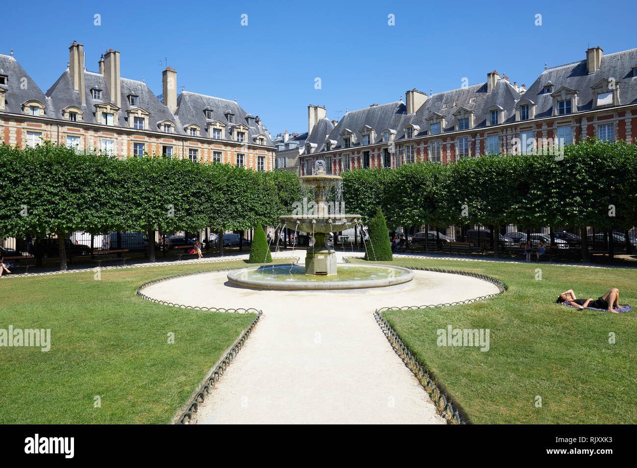 PARIS, Frankreich, 6. Juli 2018: Place des Vosges mit Menschen auf Gras und Bank in einem sonnigen Sommertag, klare blaue Himmel in Paris. Stockfoto