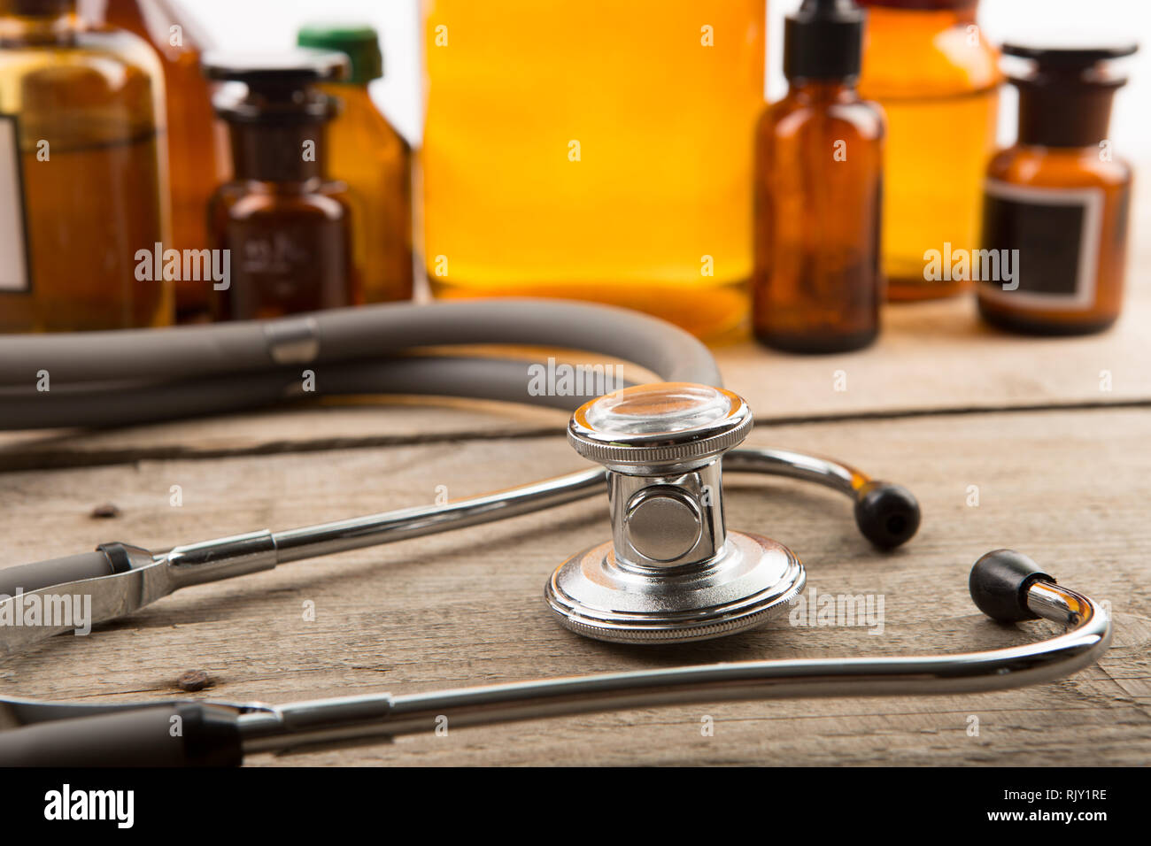 Arbeitsplatz des Arztes - Stethoskop und Apotheke Flaschen auf dem Schreibtisch aus Holz Stockfoto