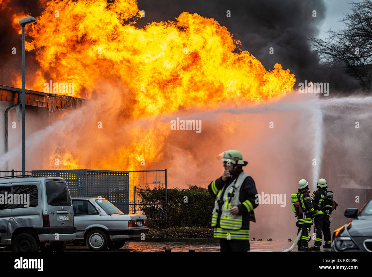 Moers, Deutschland. 08 Feb, 2019. Feuerwehrmänner bekämpfen einen Brand in einem kommerziellen Halle. Die Moers Bahnhof wurde aufgrund der starken Rauchentwicklung geschlossen. Anwohner wurden gebeten, von der Feuerwehr, Türen und Fenster geschlossen zu halten. Credit: Christoph Reichwein/dpa/Alamy leben Nachrichten Stockfoto