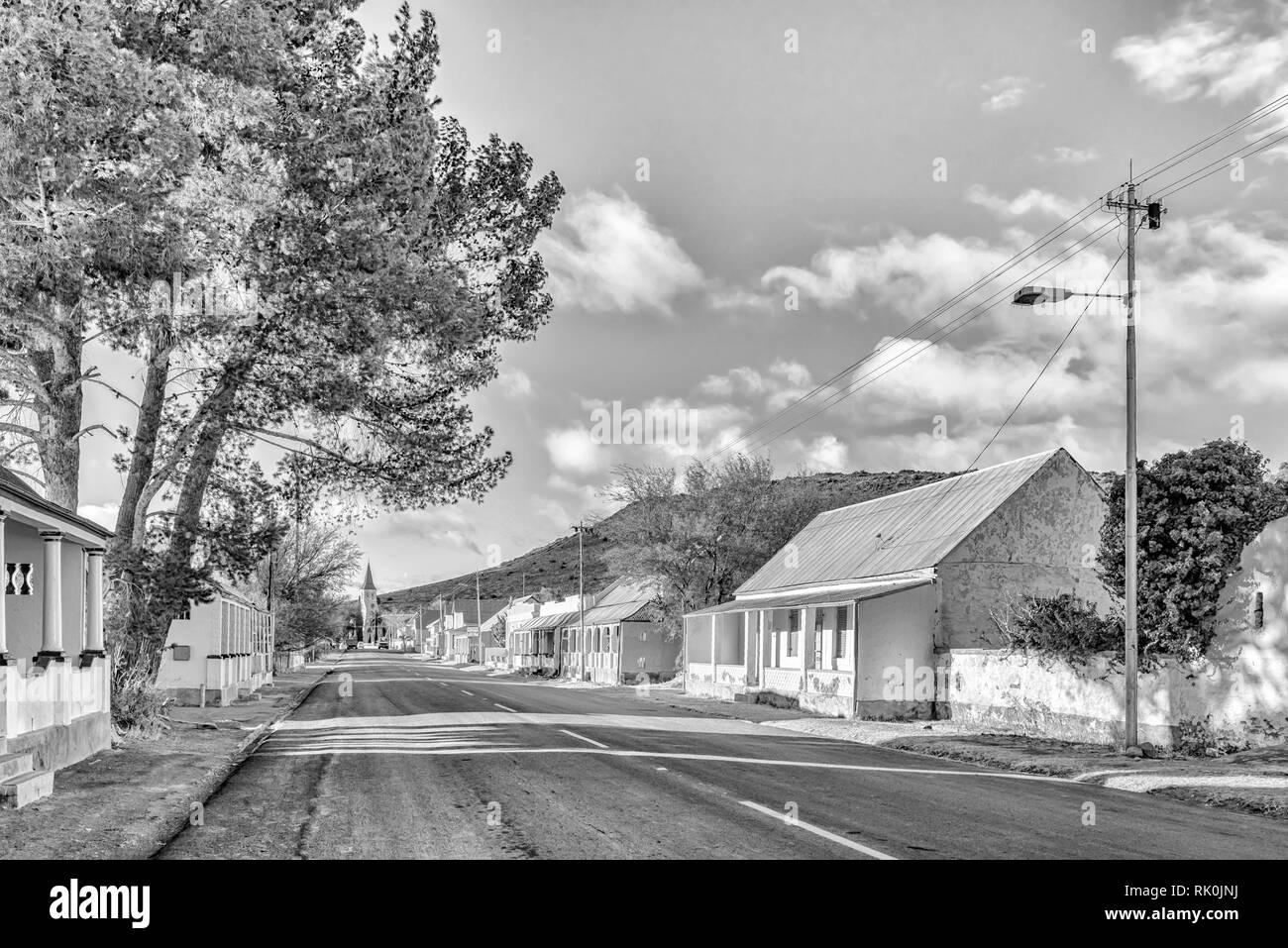 VICTORIA WEST, SÜDAFRIKA, August 7, 2018: eine Straße, Szene, mit historischen Häusern und der Niederländischen Reformierten Kirche, in Victoria West im nördlichen Kap Stockfoto