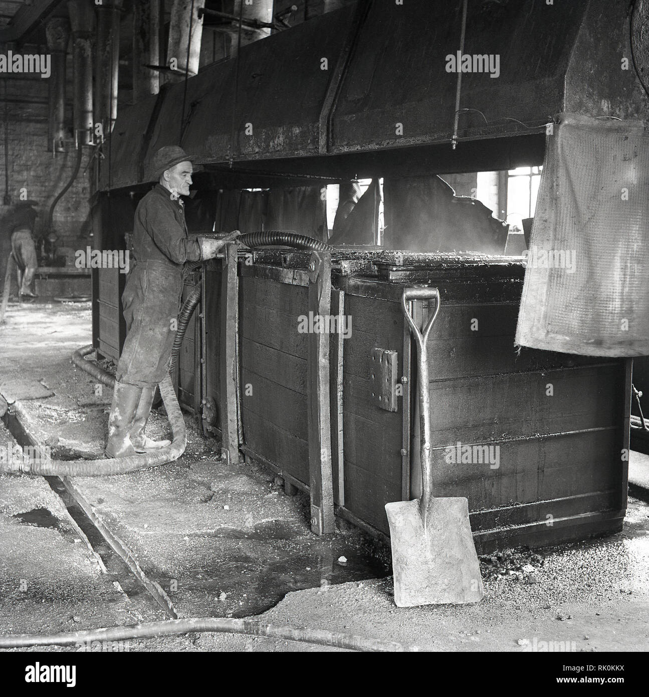 1950 s, historischen, einen Mann in Overalls in der Fabrik auf die Rohstoffe bei der Herstellung von Zink-Kohle-Batterien, England bei der Arbeit, UK Stockfoto