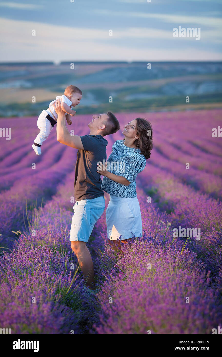 Family Portrait Mutter Vater und Sohn auf lavendelfeld gemeinsam Spaß zu haben. Glückliches Paar mit Kind genießen Urlaub tragen Einfache blaue Jeans clo Stockfoto