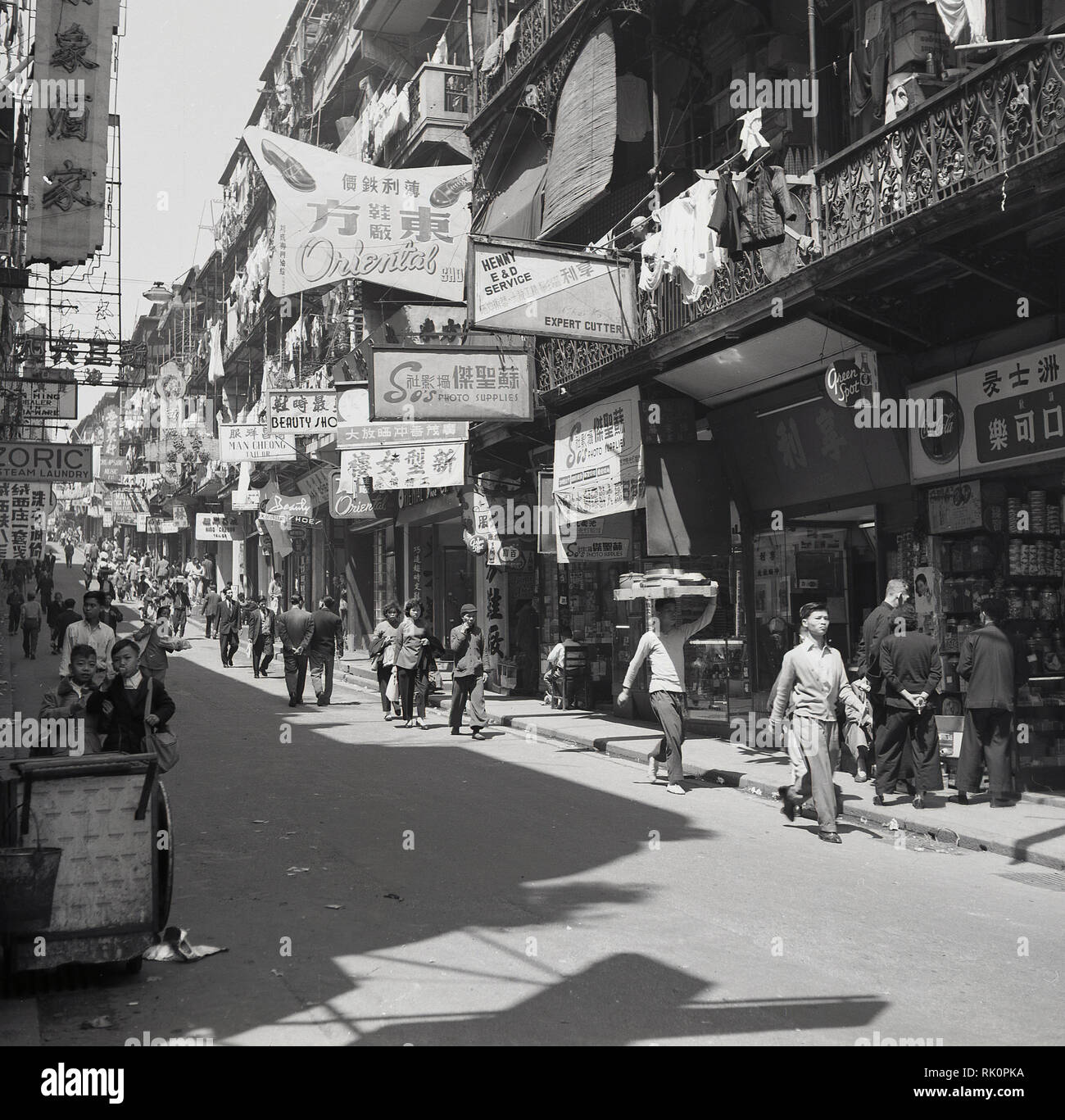 1950, historische Straße in der Altstadt, Hongkong, mit der Mischung aus Einzelhandel, auf Straßenebene und Wohnbereich oben, in der Mitte der 1950er Jahre, Bevölkerungsdichte im Gebiet wäre eine der höchsten in der Welt geworden. Stockfoto