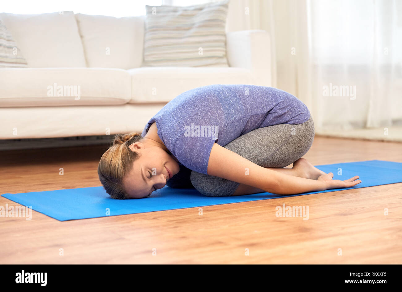 Frau yoga Embryostellung zu Hause Stockfoto