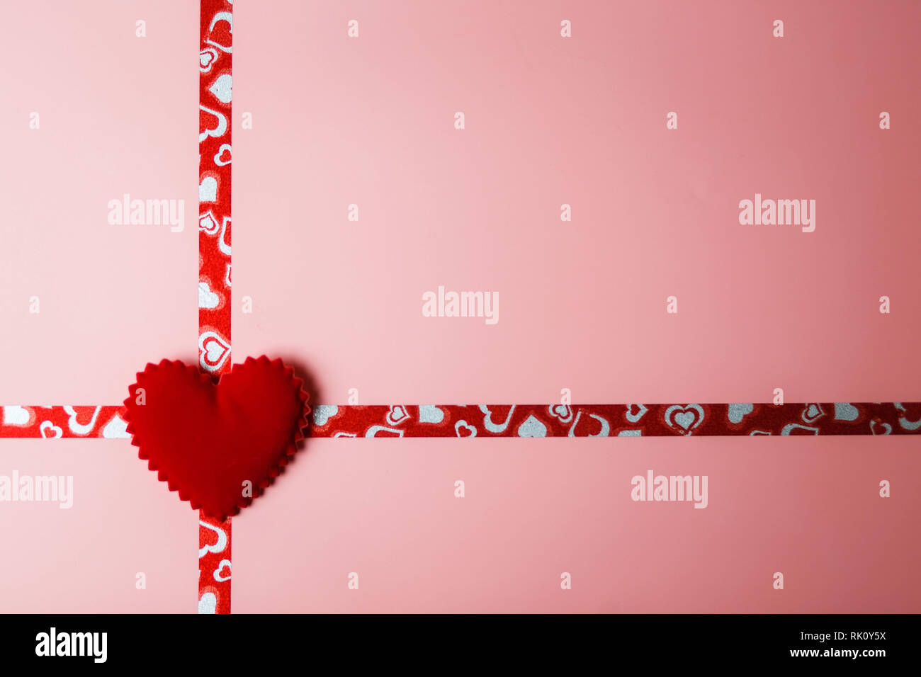 Ein Geschenk für den Valentinstag oder eine Hochzeit. Rosa Verpackung mit Bändern und rotem Samt Herz mit Kopie Raum Stockfoto