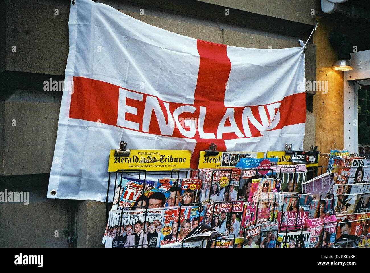 England Fahne mit dem Kreuz von St. George, vor Zeitschriften an einen Zeitungsladen stand in Manchester, Großbritannien Stockfoto