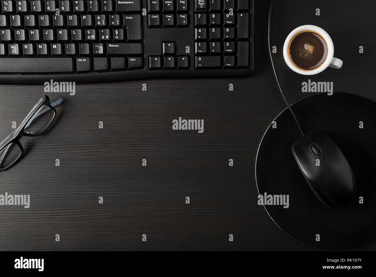 Insgesamt schwarzen Schreibtisch mit PC- und Tasse Kaffee Stockfoto