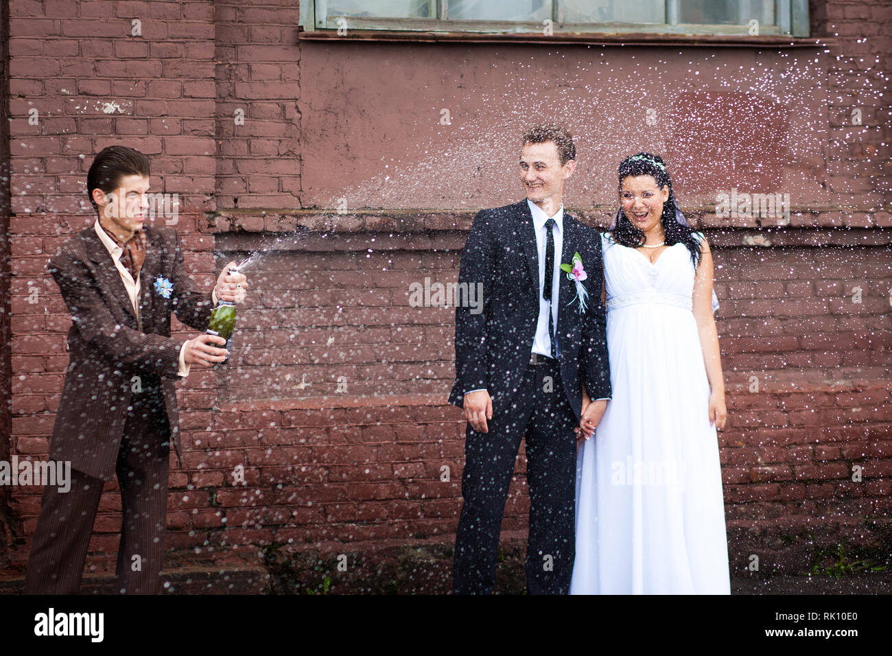 Ein Zeuge bei der Hochzeit geöffnet Champagner mit Farbakzenten Stockfoto