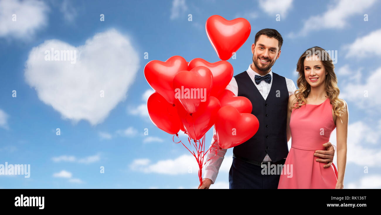 Glückliches Paar mit roten herzförmigen Luftballons Stockfoto