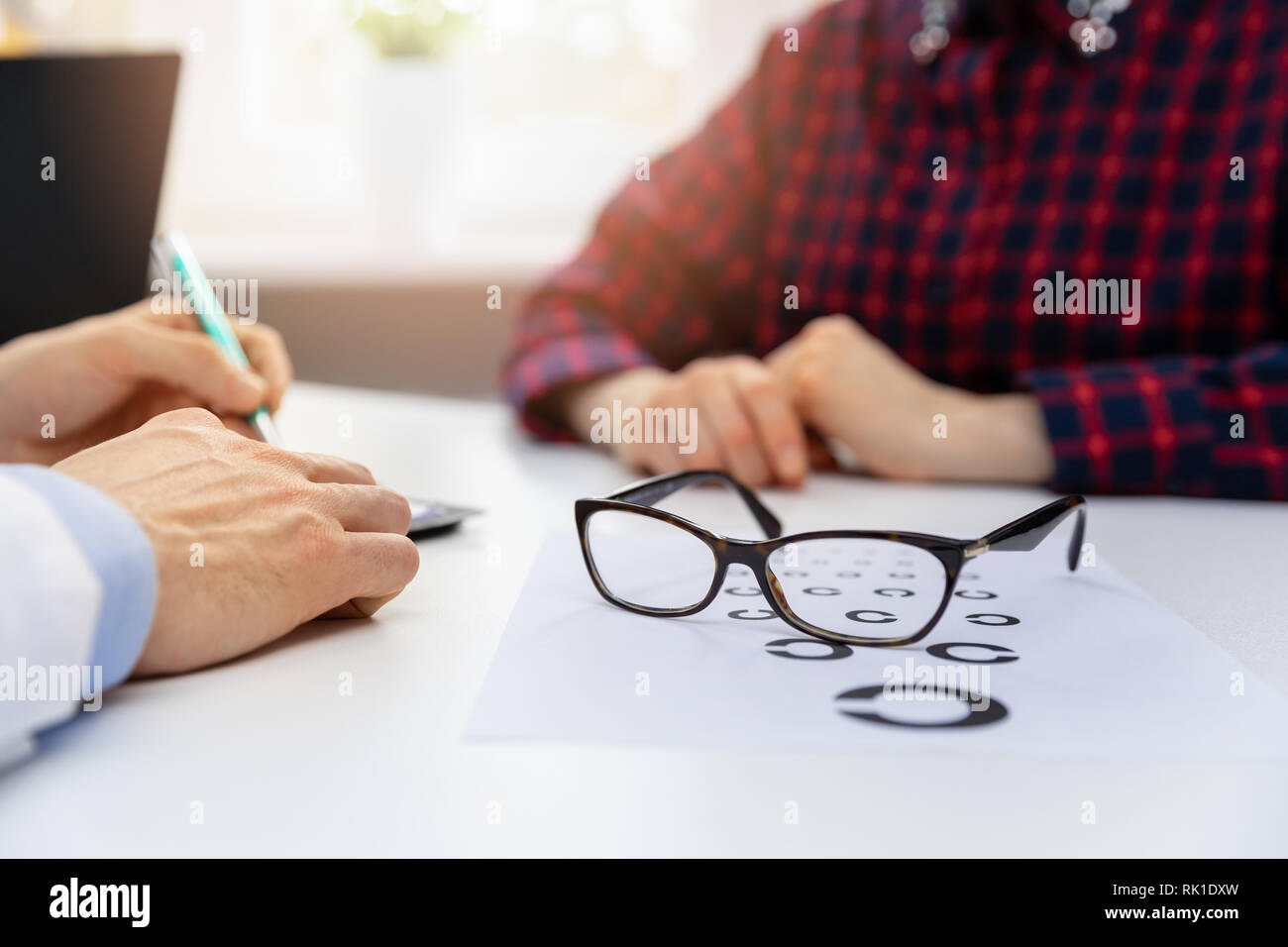 Die Gesundheit der Augen - schwarze Brille auf Sehvermögen Test Chart in Optiker Büro Stockfoto
