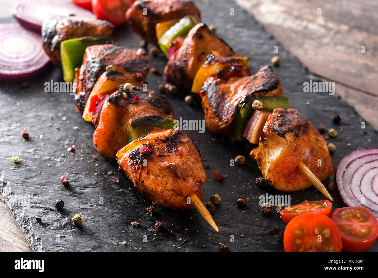 Hühnchen Shish Kebab mit Gemüse auf schwarzen Stein Stockfoto